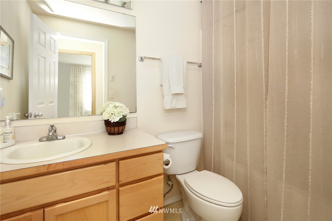 7503 Seashell Way Blaine, WA 98230 - Photo 25 of 31 a bathroom with a sink a toilet and shower curtain