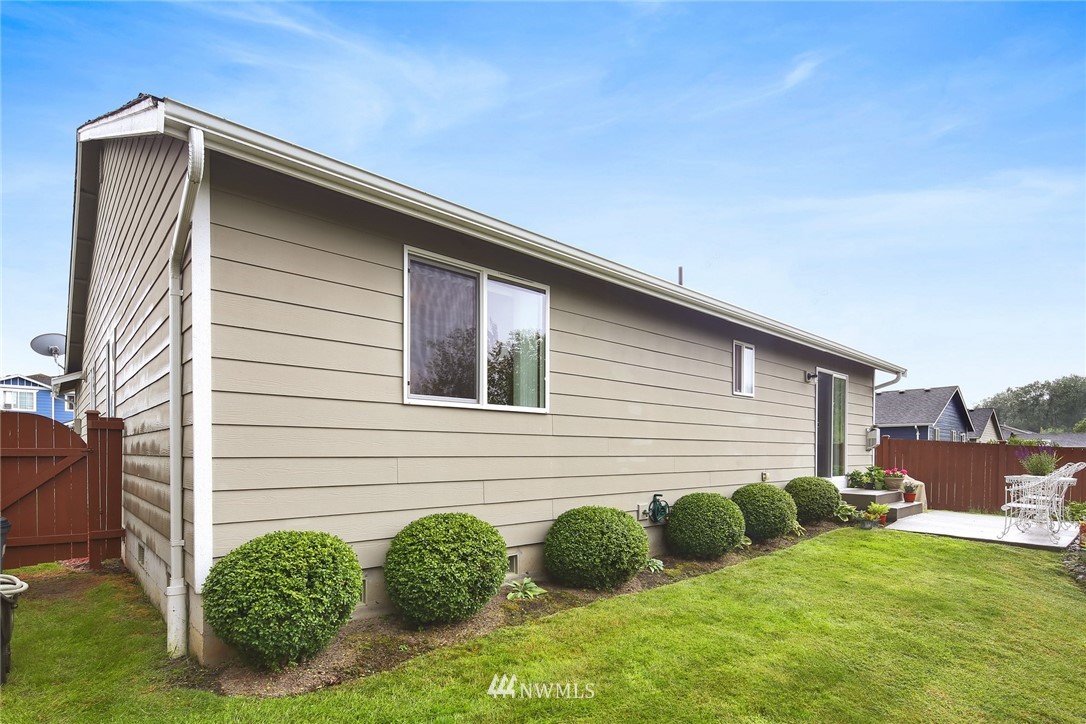 7503 Seashell Way Blaine, WA 98230 - Photo 30 of 31 a backyard of a house with plants and barbeque oven