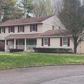 a front view of a house with a garden and yard