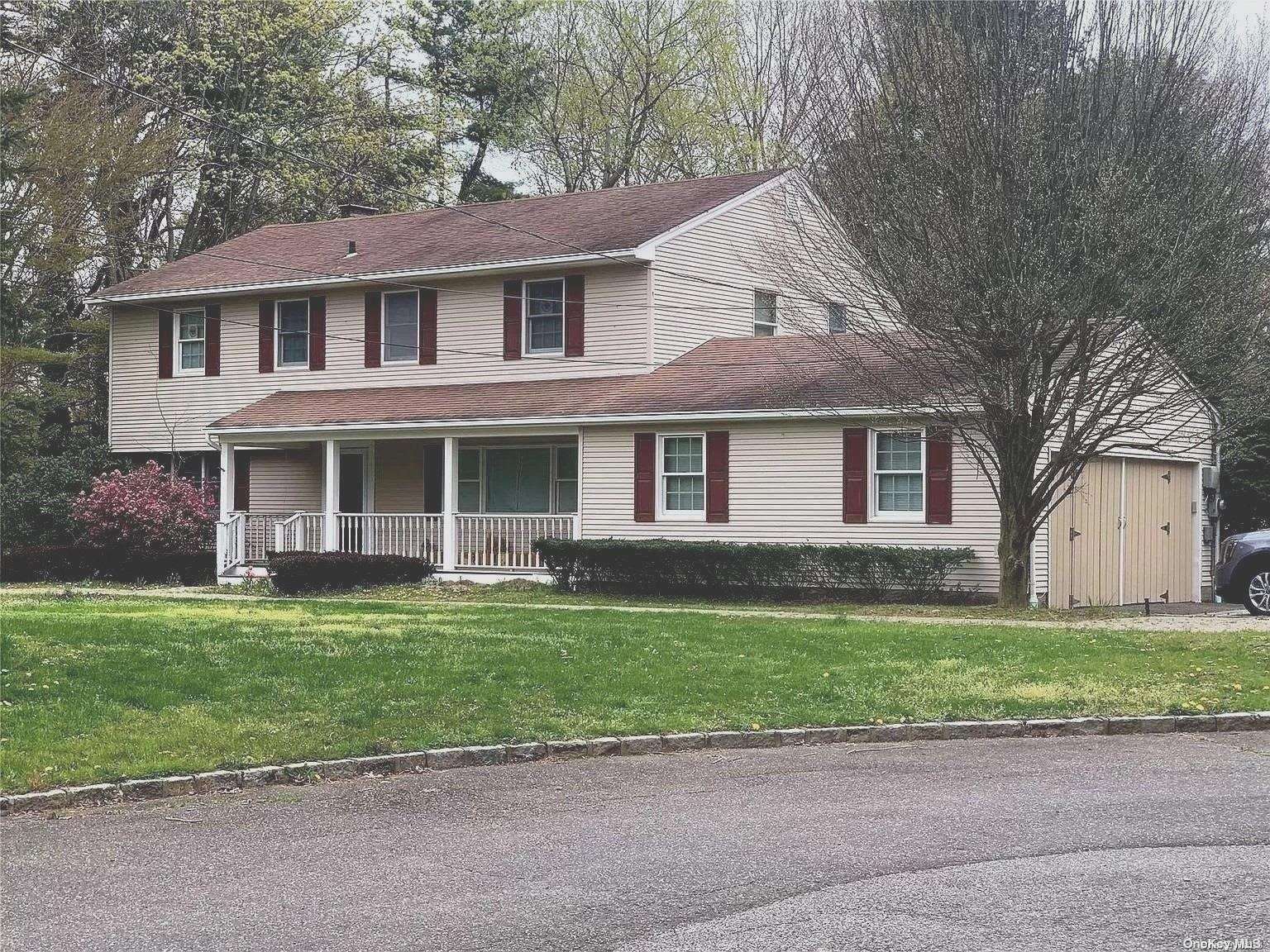 a front view of a house with a garden and yard