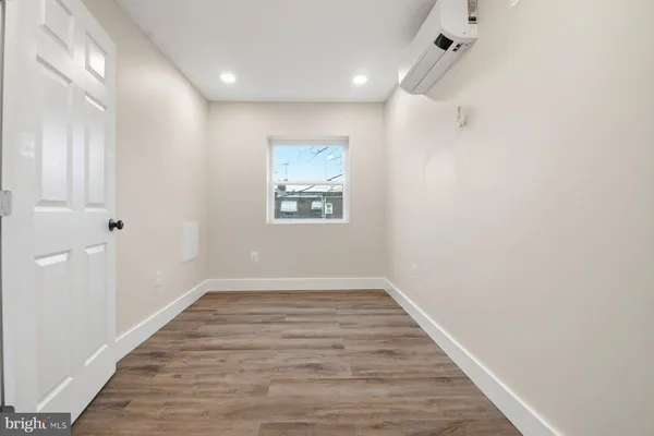 a view of an empty room with wooden floor
