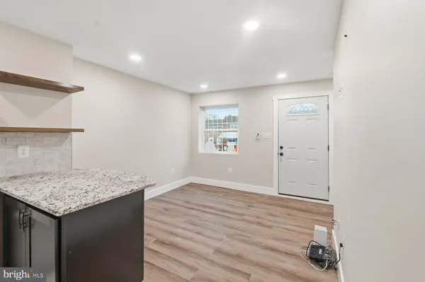 an empty room with wooden floor and a hallway