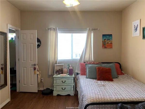a bedroom with a bed and wooden floor