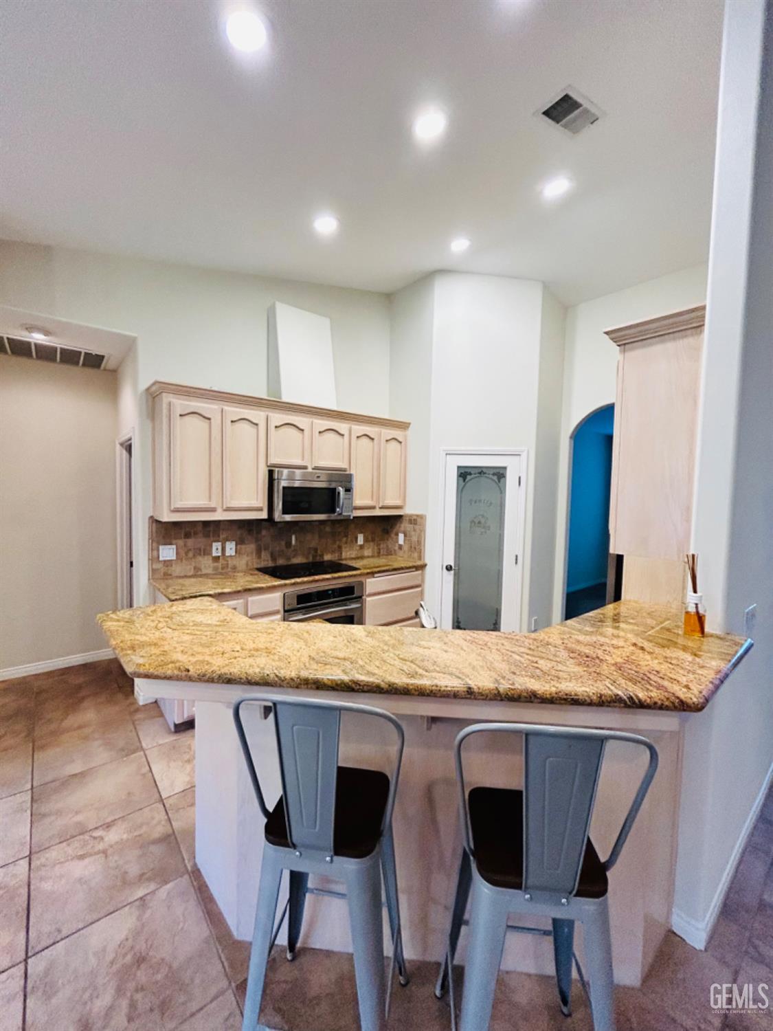 Undisclosed Address Taft, CA 93268 - Photo 14 of 27 a kitchen with stainless steel appliances kitchen island granite countertop a kitchen island and chairs in it