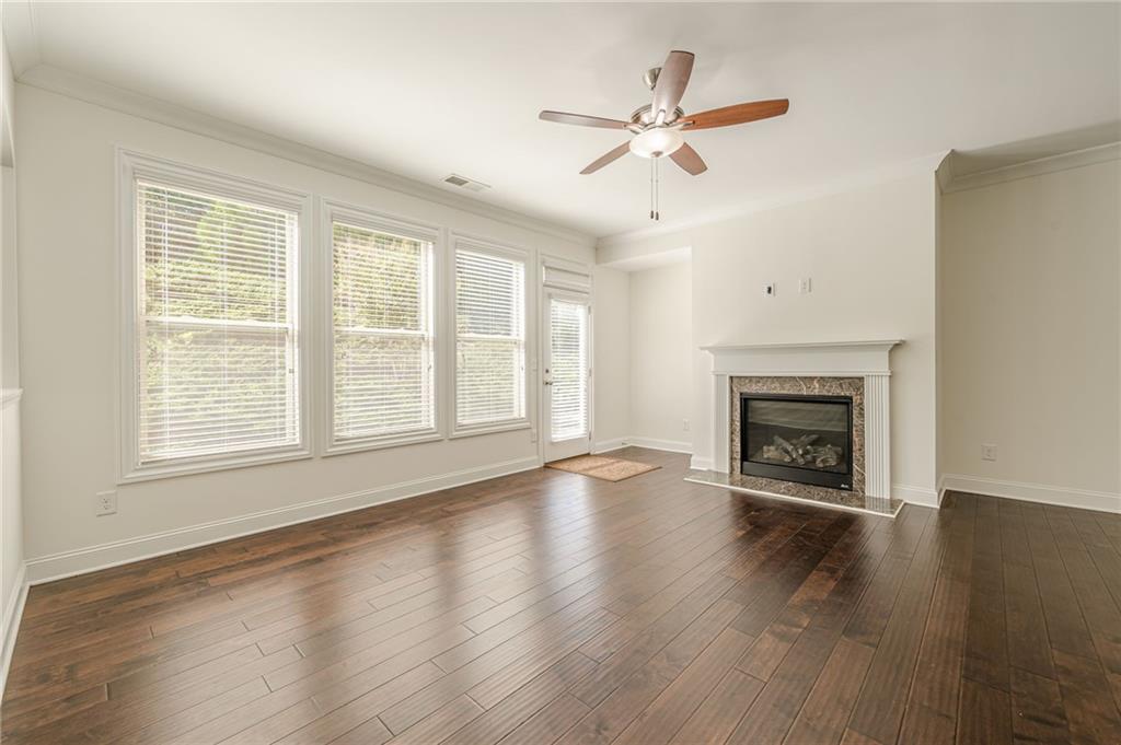 1040 Peyton View Court Alpharetta, GA 30004 - Photo 19 of 53 an empty room with wooden floor fireplace and windows