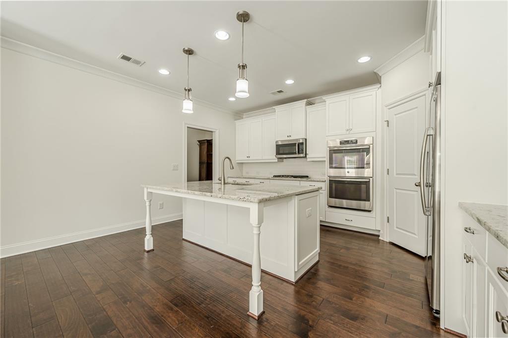 1040 Peyton View Court Alpharetta, GA 30004 - Photo 27 of 53 a kitchen with white cabinets and stainless steel appliances