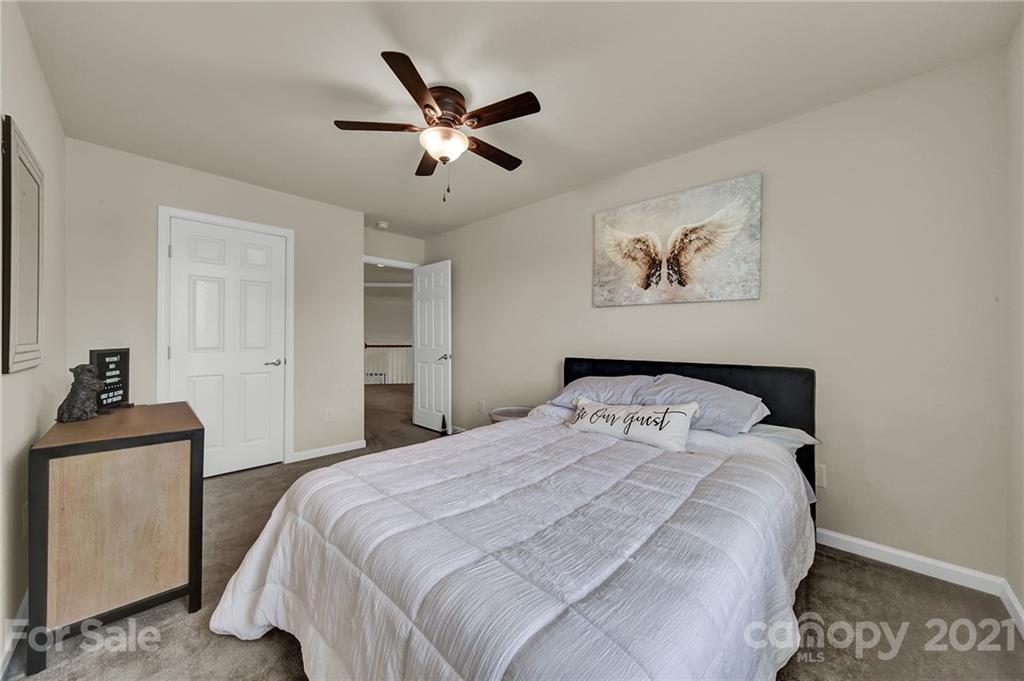 107 Inlet Point Drive Tega Cay, SC 29708 - Photo 16 of 24 a bedroom with a large bed and a chandelier