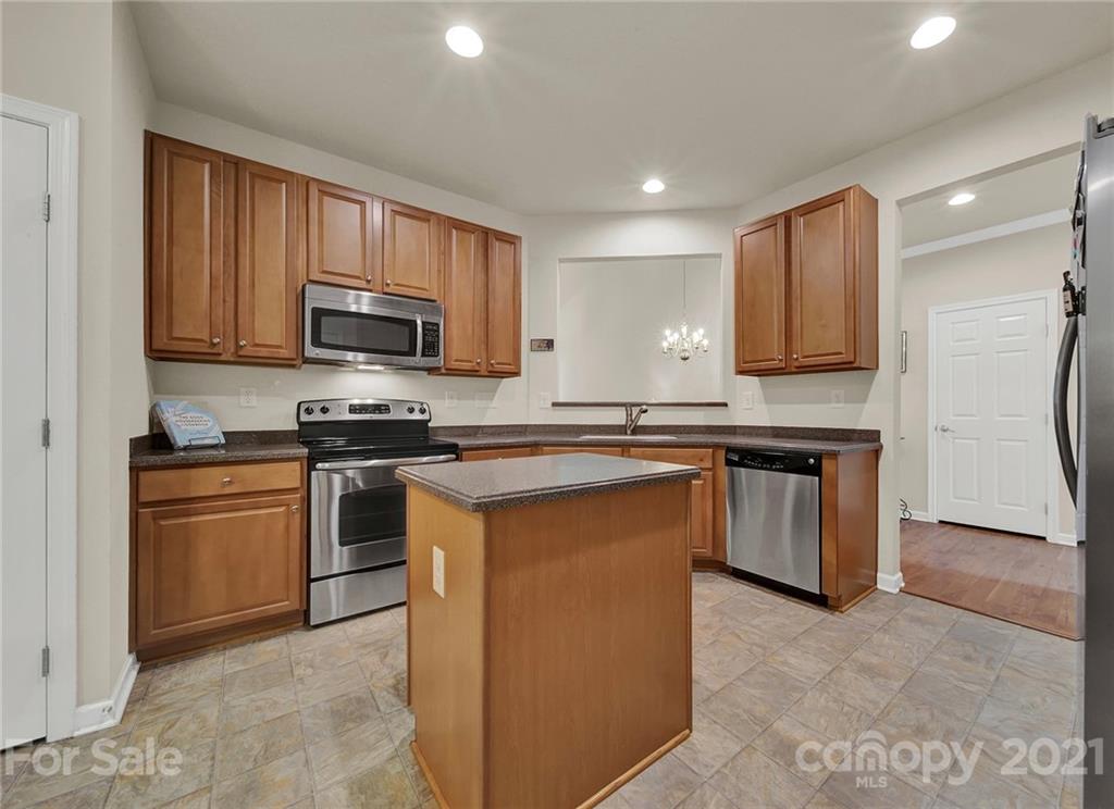 107 Inlet Point Drive Tega Cay, SC 29708 - Photo 5 of 24 a kitchen with stainless steel appliances granite countertop a stove a sink dishwasher a refrigerator and a microwave
