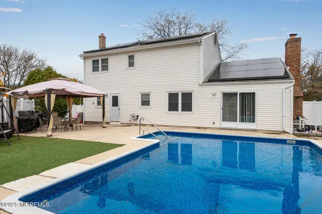 a view of a white house with a swimming pool