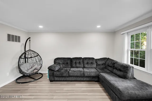 a living room with furniture a window and gym equipment