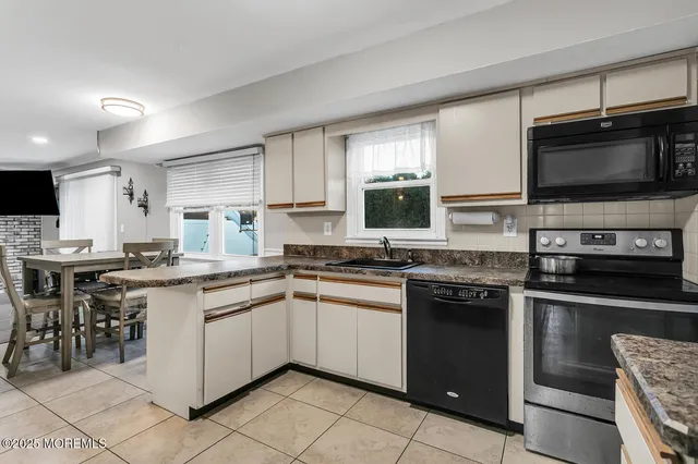 a kitchen with stainless steel appliances granite countertop a stove top oven a sink dishwasher a dining table and chairs