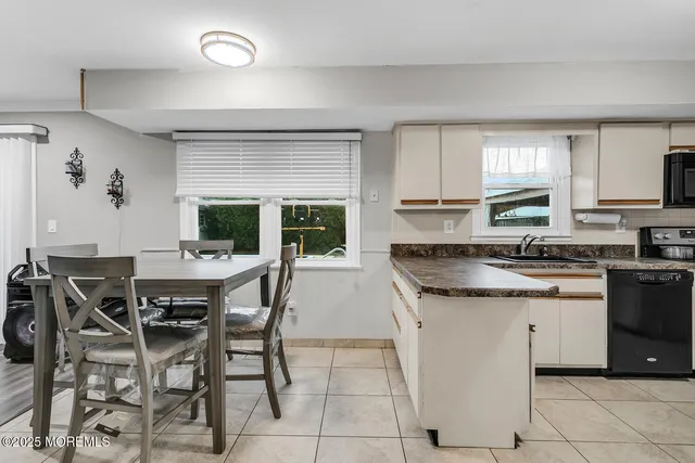 a kitchen with granite countertop a table chairs sink and cabinets