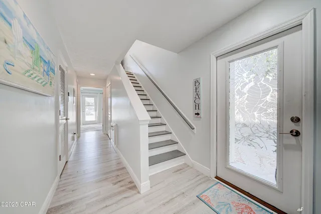 a view of a hallway with wooden floor and entryway