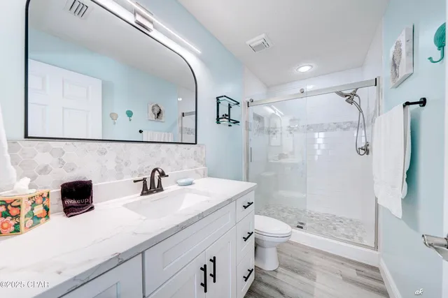 a bathroom with a sink a toilet and shower