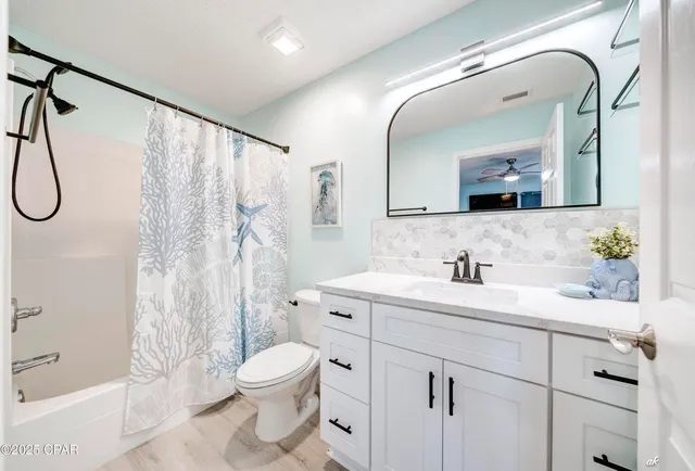 a bathroom with a granite countertop sink a toilet and a bathtub