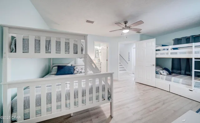 a bedroom with furniture and a chandelier fan