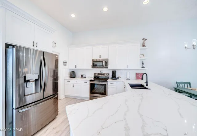 a kitchen with granite countertop stainless steel appliances and refrigerator