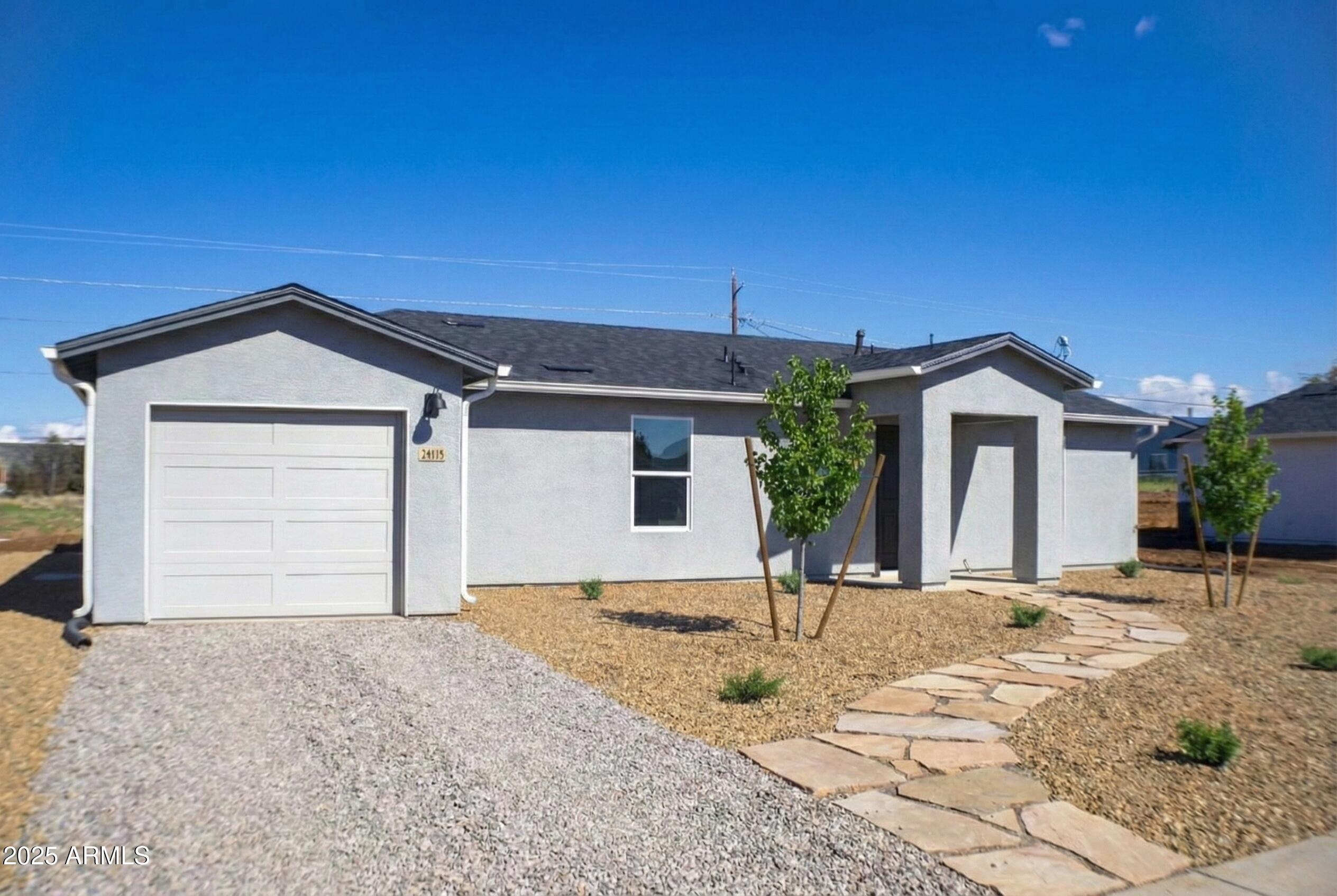 a view of house with backyard and parking space