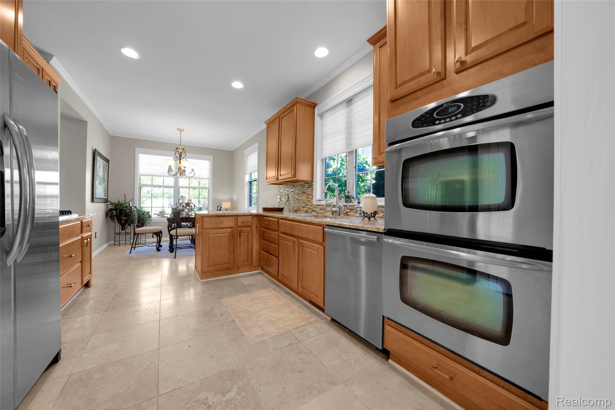 3805 Windingbrook Circle, Unit 22 Rochester, MI 48309 - Photo 27 of 63 Gourmet kitchen featuring stainless steel appliances, double wall ovens, wood cabinetry, stone countertops, and tile flooring