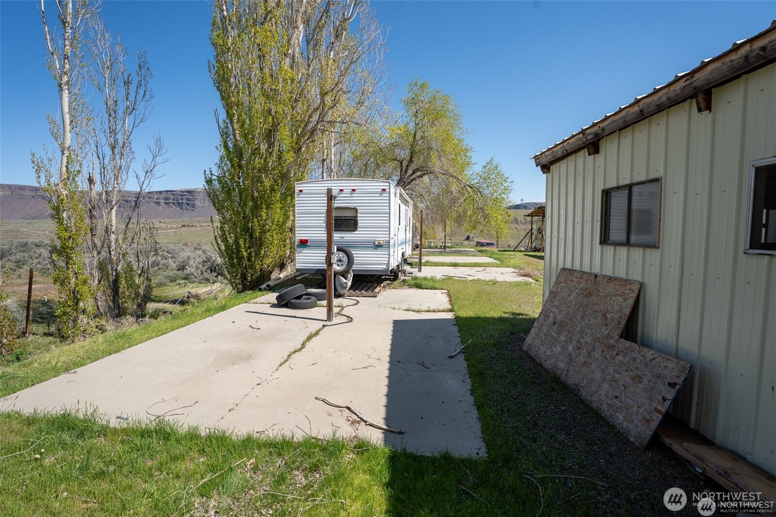 7199 Tarpiscan Road Malaga, WA 98828 - Photo 8 of 12 a view of a patio with couches table and chairs with wooden floor and fence