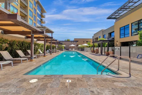 a patio with a table and chairs and potted plants