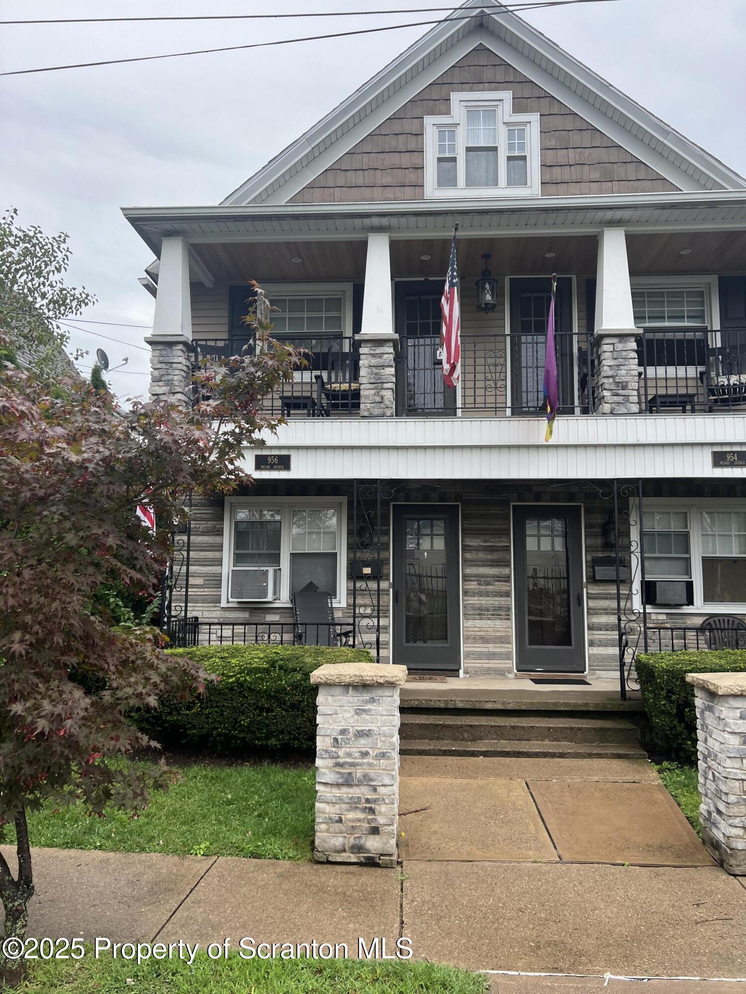 956 Meade Avenue, Unit 1 Scranton, PA 18508 - Photo 11 of 11 a view of a white house with large windows and a small yard