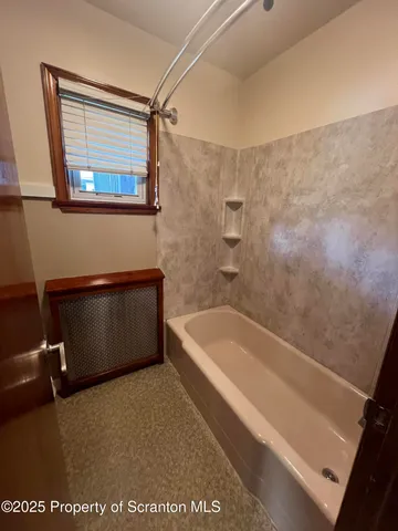 a bath tub sitting next to a blue sink and a shower