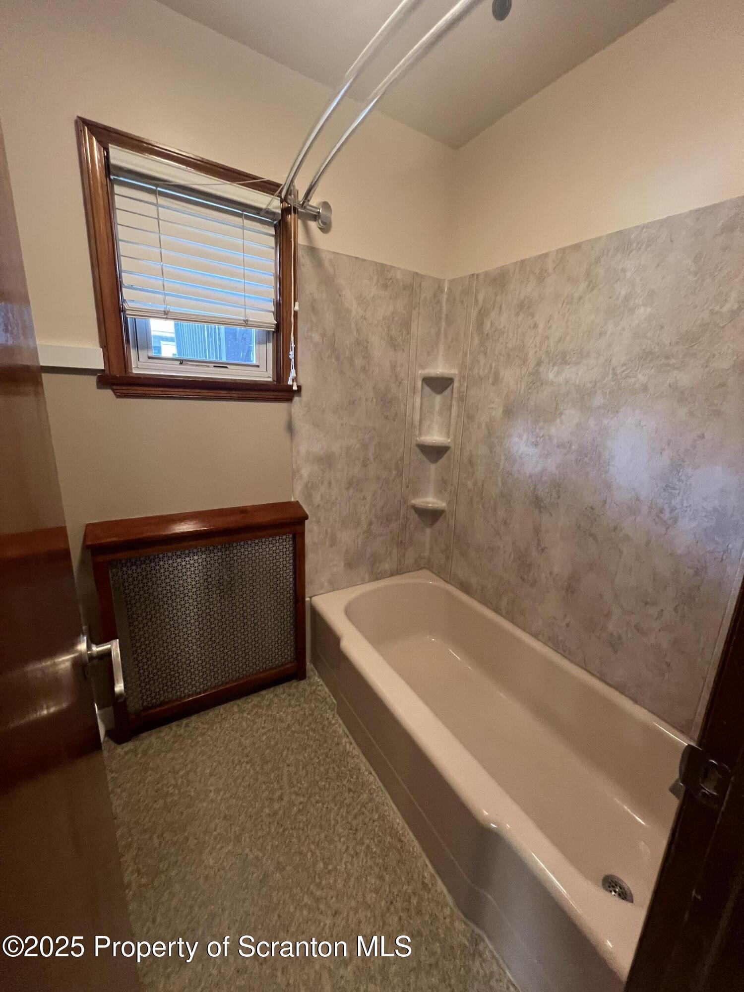 956 Meade Avenue, Unit 1 Scranton, PA 18508 - Photo 6 of 11 a bath tub sitting next to a blue sink and a shower