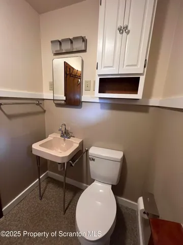 a bathroom with a toilet a sink and a mirror
