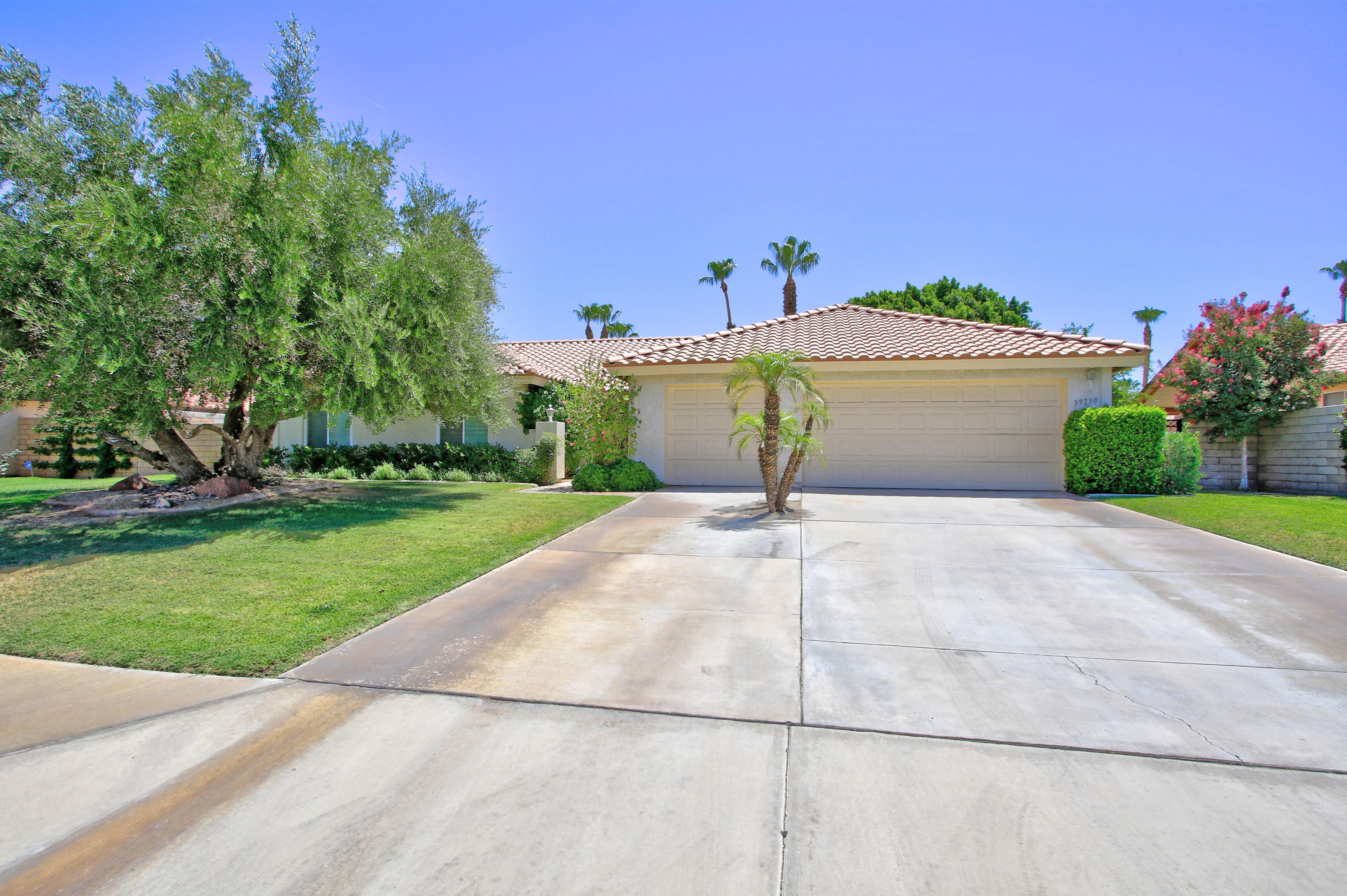 39730 Regency Way Palm Desert, CA 92211 - Photo 2 of 35 a front view of a house with a yard and garage
