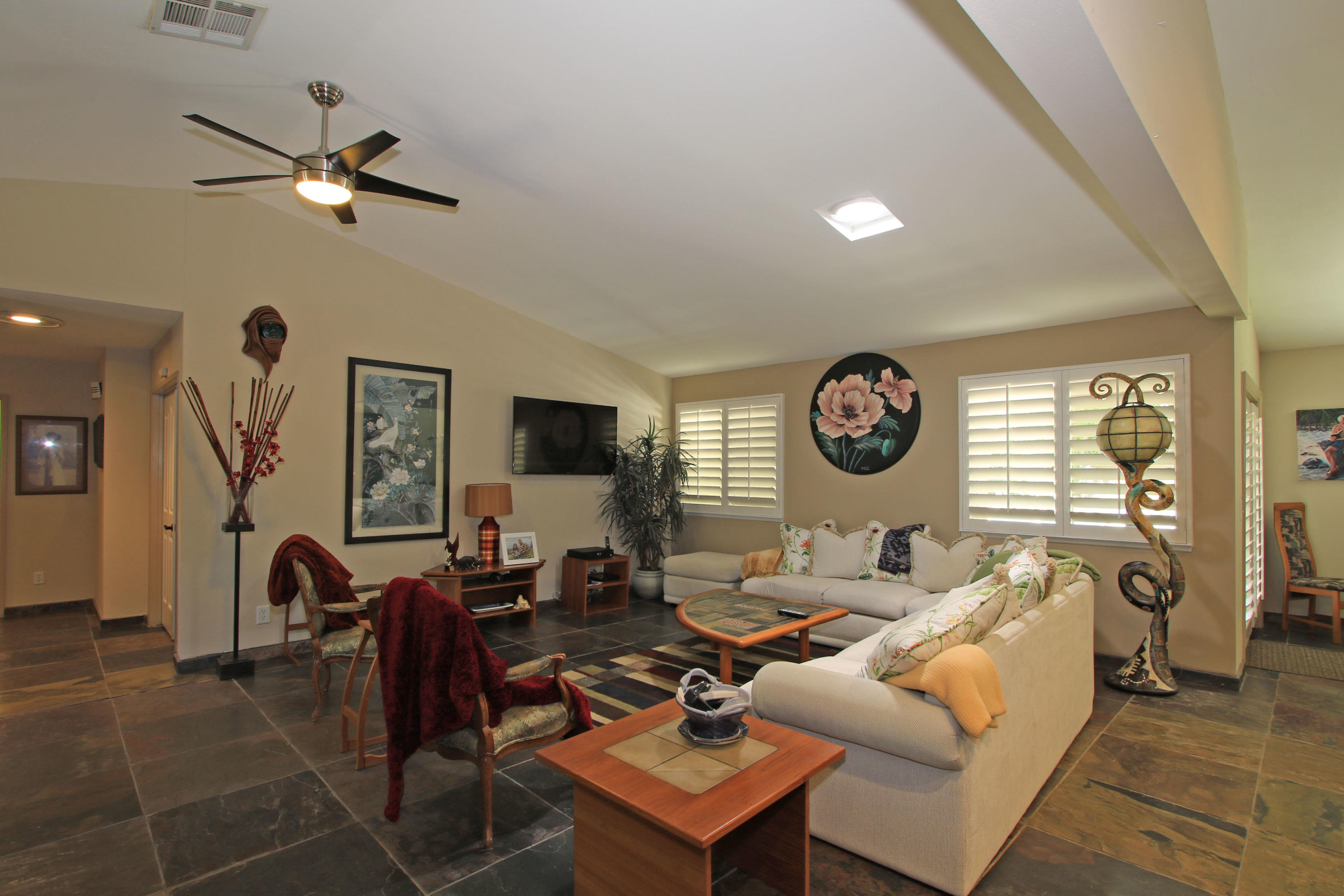 39730 Regency Way Palm Desert, CA 92211 - Photo 21 of 35 a living room with furniture a clock on wall and a window
