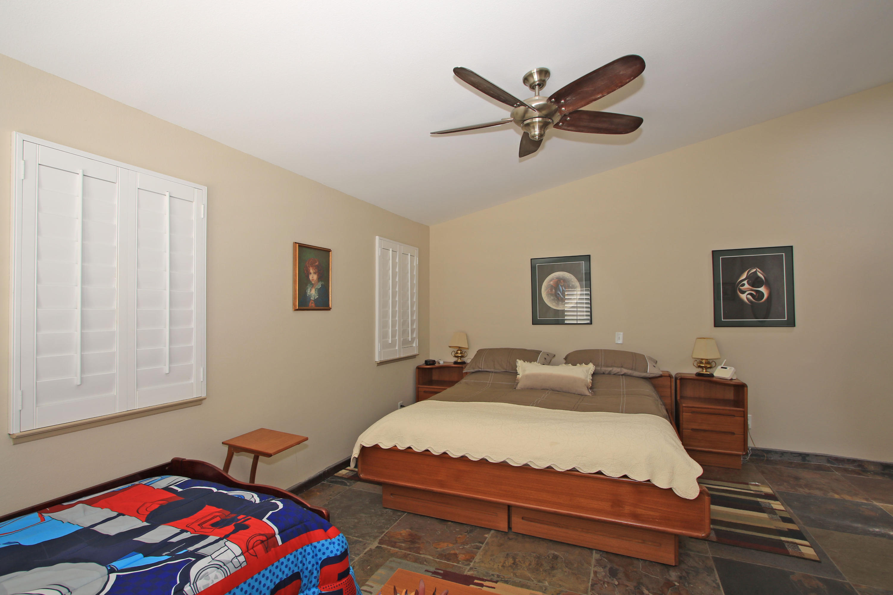 39730 Regency Way Palm Desert, CA 92211 - Photo 27 of 35 a bedroom with a bed and a chandelier