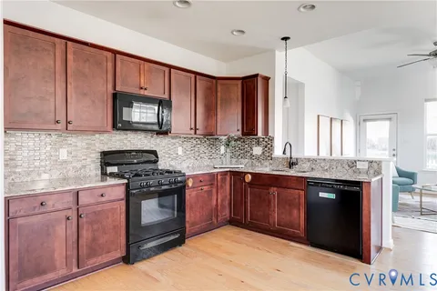a kitchen with stainless steel appliances granite countertop wooden cabinets stove top oven and sink