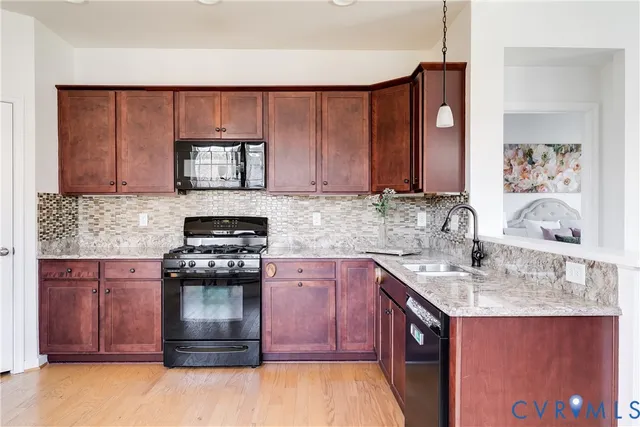 a kitchen with stainless steel appliances granite countertop a stove a sink and a microwave