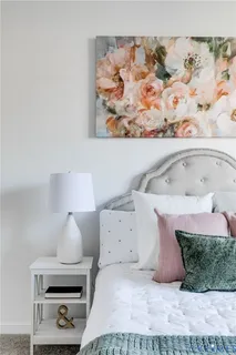 a room with a bed and a painting on the wall