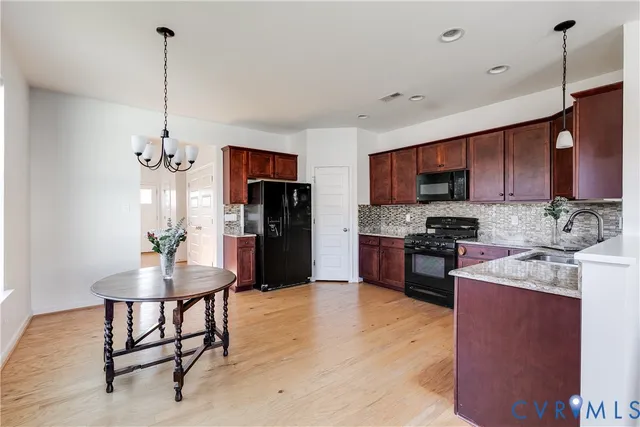 a kitchen with refrigerator a sink and chairs