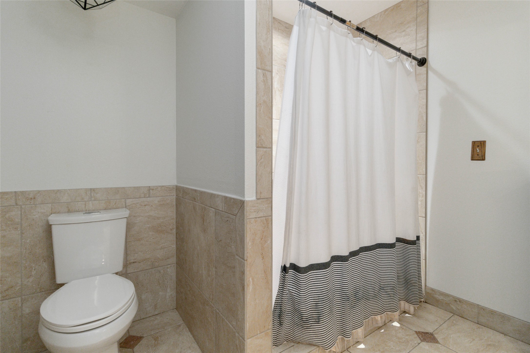 180 Ironstone Road Smithville, TX 78957 - Photo 11 of 37 Bathroom with a shower with curtain, tile walls, and tile patterned flooring