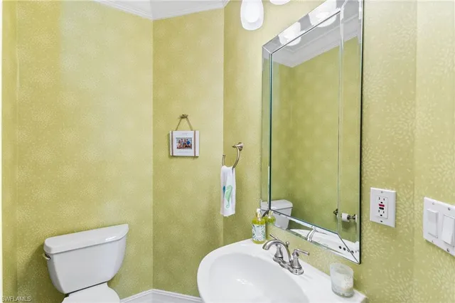 a bathroom with a sink mirror and toilet