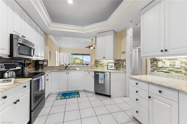 a kitchen with white cabinets appliances and sink