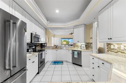a kitchen with white cabinets and appliances