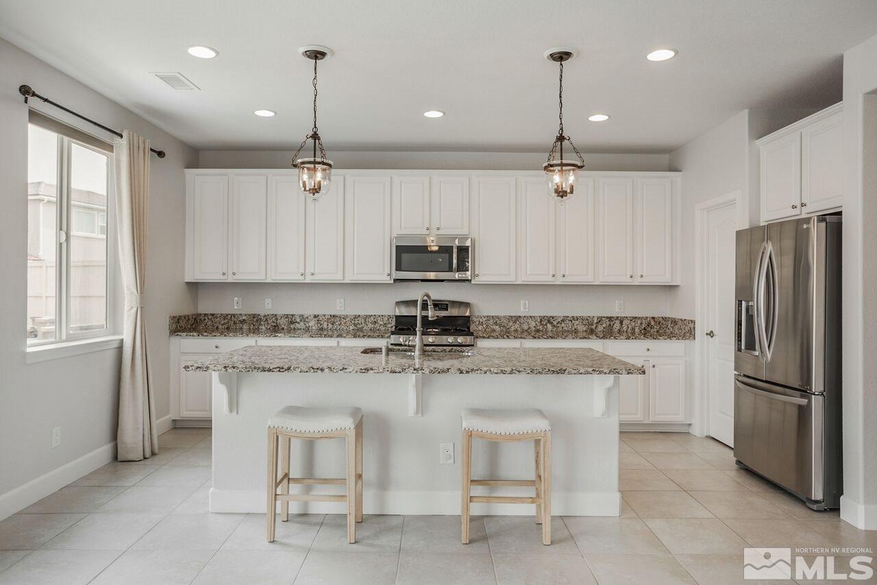 10370 Culiacan Pass Trail Reno, NV 89521 - Photo 11 of 25 a kitchen with stainless steel appliances granite countertop a stove a sink and a refrigerator