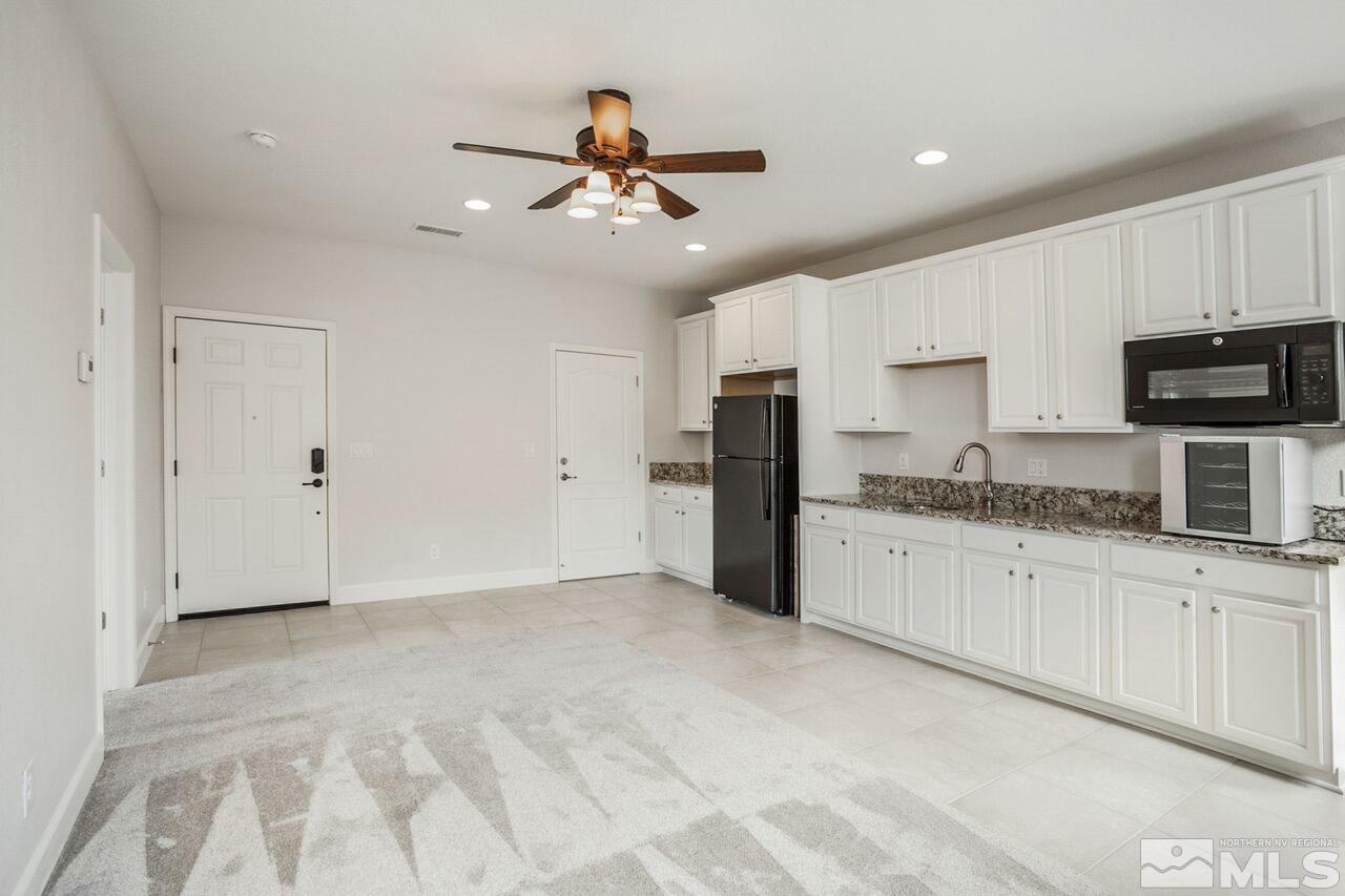 10370 Culiacan Pass Trail Reno, NV 89521 - Photo 12 of 25 a kitchen with granite countertop a refrigerator oven a sink and white cabinets