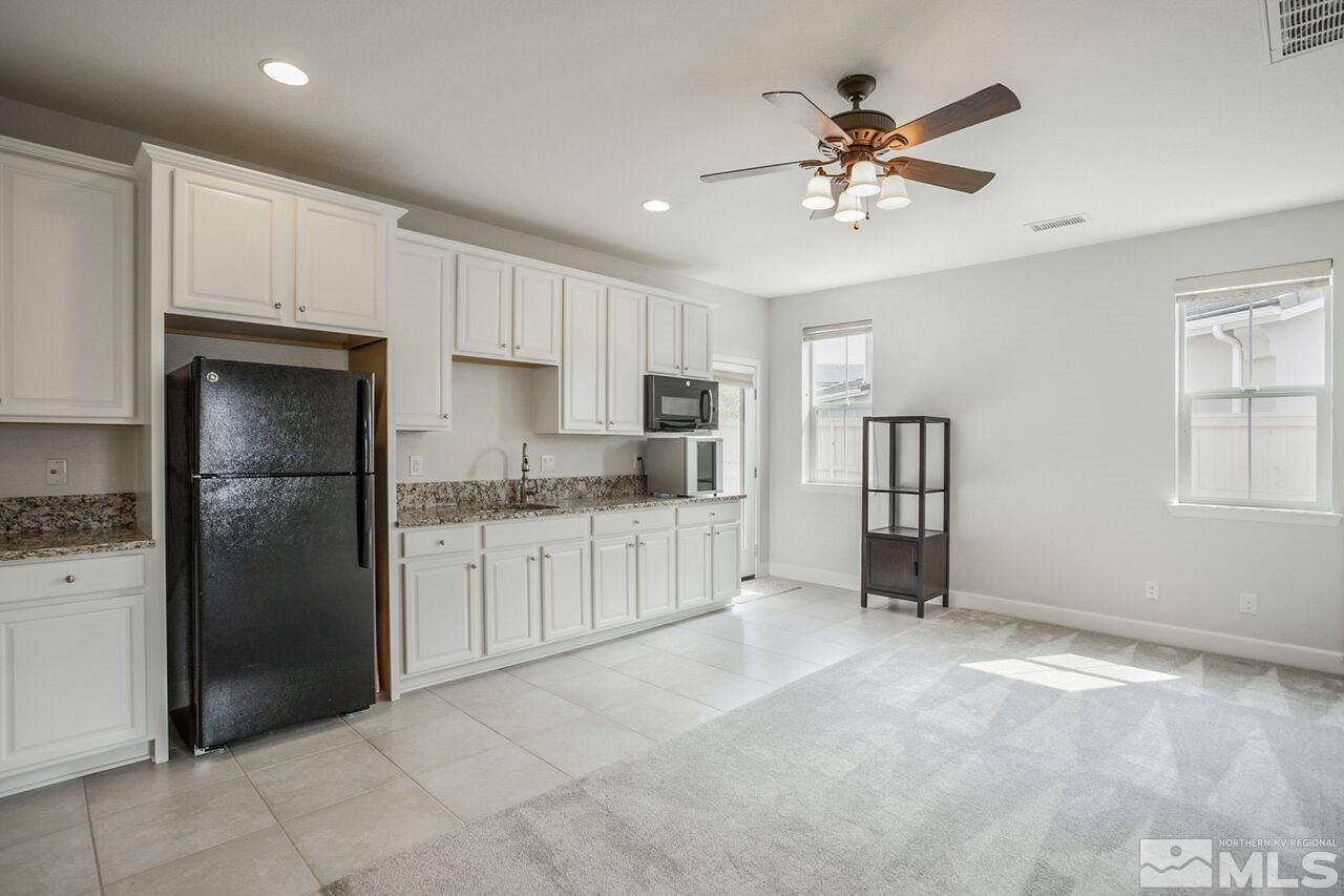 10370 Culiacan Pass Trail Reno, NV 89521 - Photo 13 of 25 a kitchen with white cabinets and refrigerator