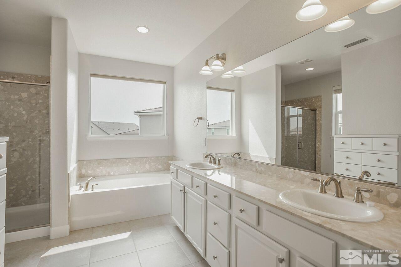 10370 Culiacan Pass Trail Reno, NV 89521 - Photo 19 of 25 a spacious bathroom with a double vanity sink mirror and bathtub