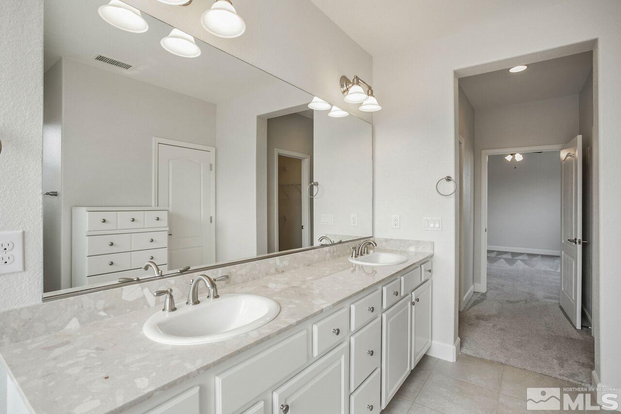 10370 Culiacan Pass Trail Reno, NV 89521 - Photo 21 of 25 a bathroom with a granite countertop double vanity sink mirror and shower