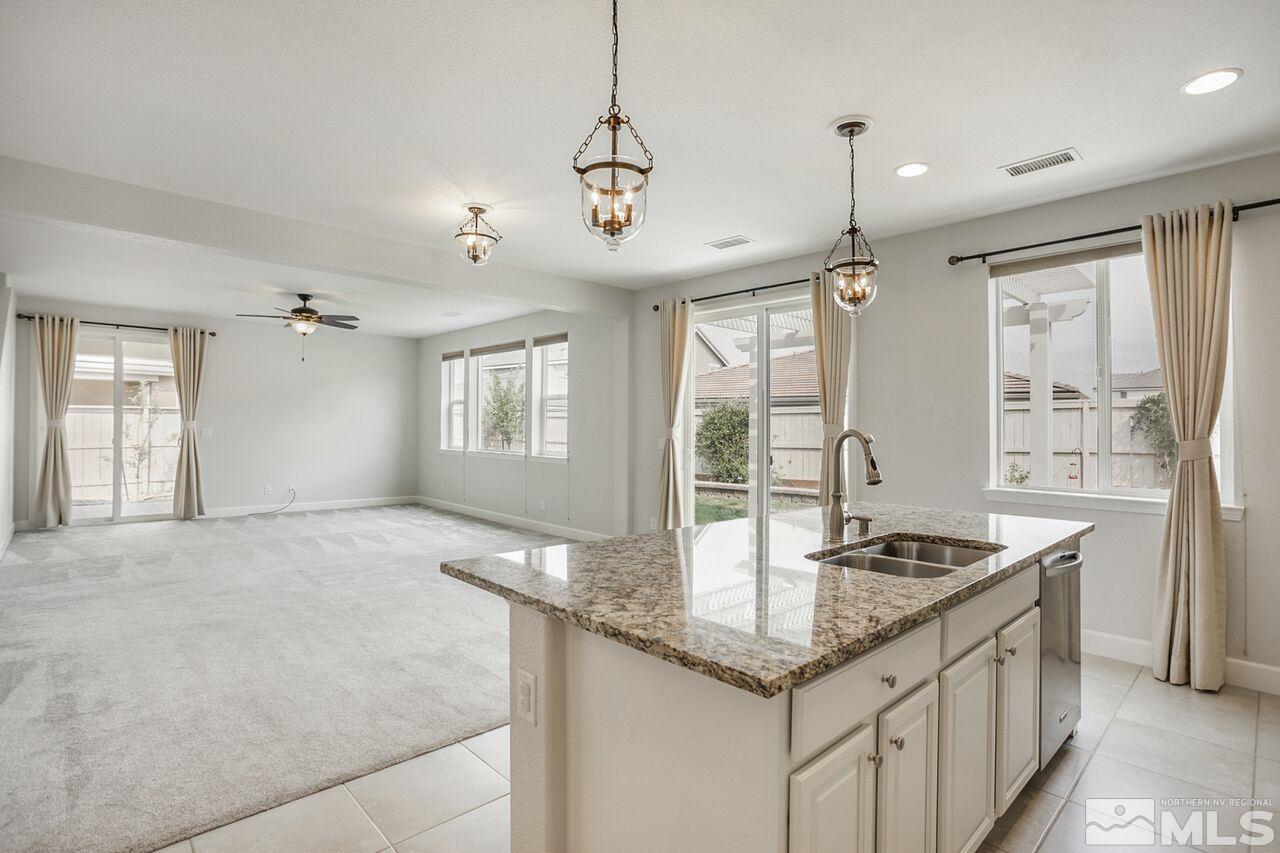 10370 Culiacan Pass Trail Reno, NV 89521 - Photo 5 of 25 a kitchen with granite countertop a sink stove and cabinets