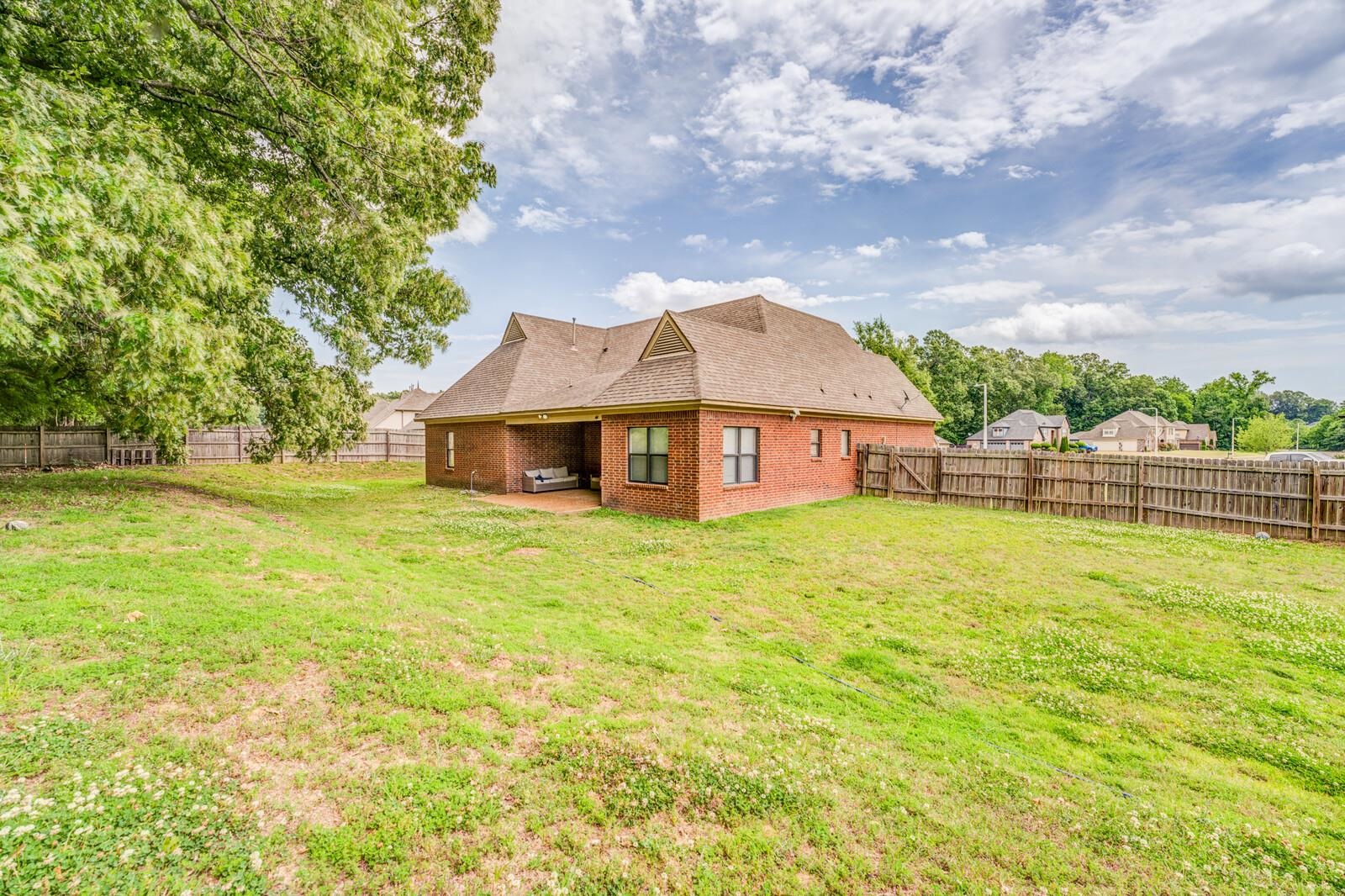 4671 Hampton Ridge Lane Bartlett, TN 38002 - Photo 36 of 40 Spacious backyard featuring a full privacy fence, mature trees, a red brick exterior, and a covered patio area