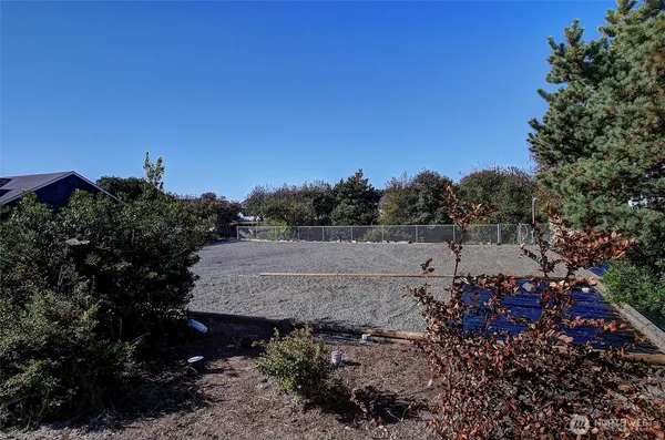 a view of a barn with green field and covered with tree