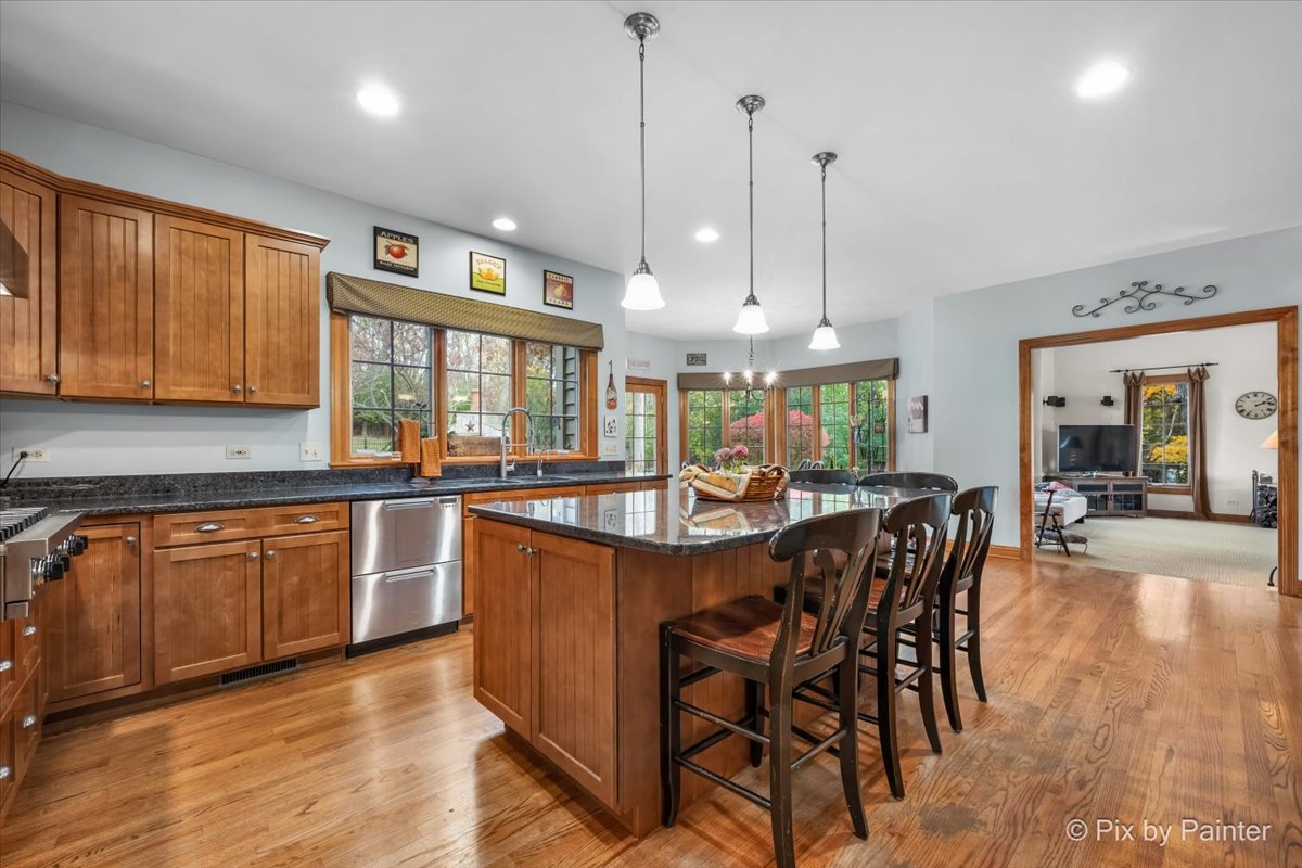 24881 North Black Walnut Cary, IL 60013 - Photo 15 of 53 a kitchen with stainless steel appliances granite countertop wooden cabinets a dining table and chairs