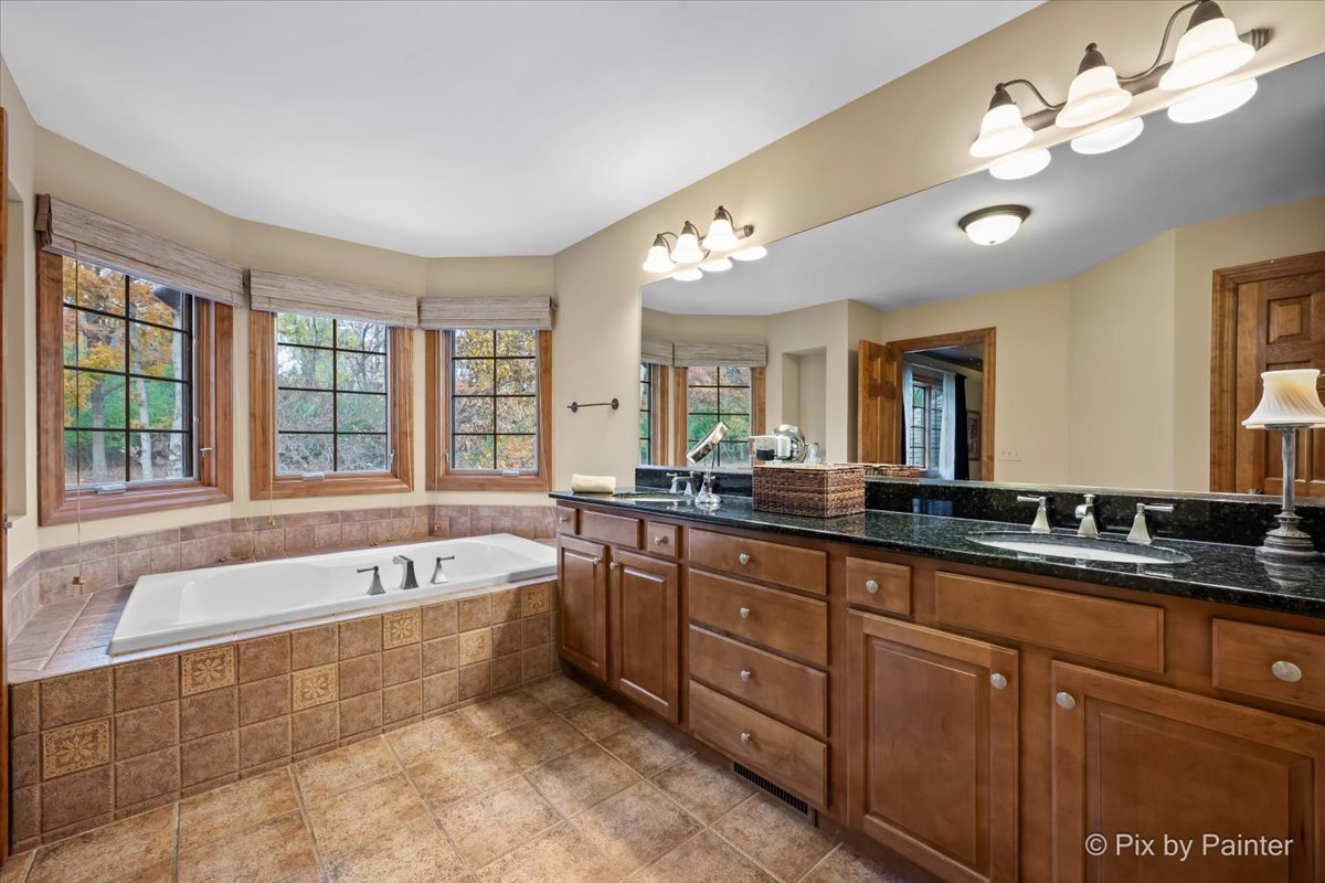 24881 North Black Walnut Cary, IL 60013 - Photo 30 of 53 a spacious bathroom with a tub a double vanity sink a large mirror and a bathtub
